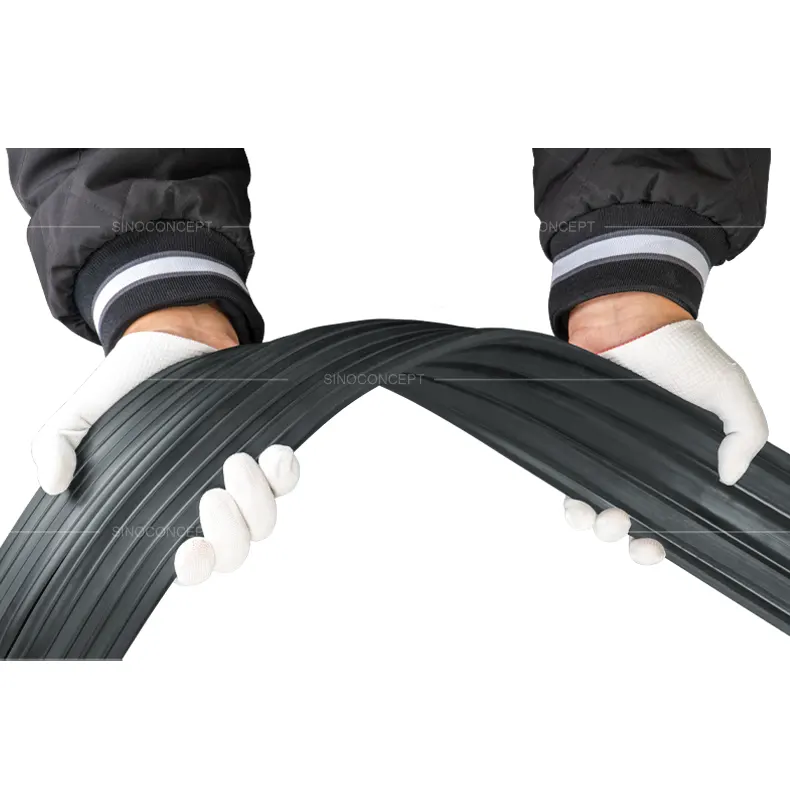 Worker demonstrating the flexibility of 1-channel floor cable cover, showing its soft yet durable flexible PVC material