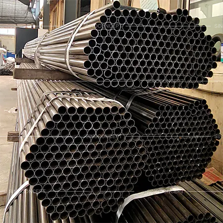 Steel tubes used for manufacturing parking barriers, stacked in a factory setting
