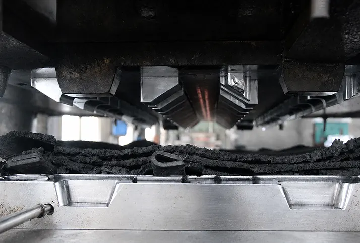 Rubber vulcanisation process with heated moulds pressing rubber material in production