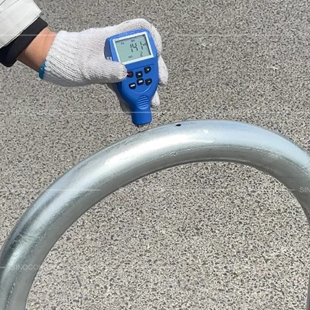 Coating thickness test on galvanised hoop barriers and lamp post protectors during quality inspection