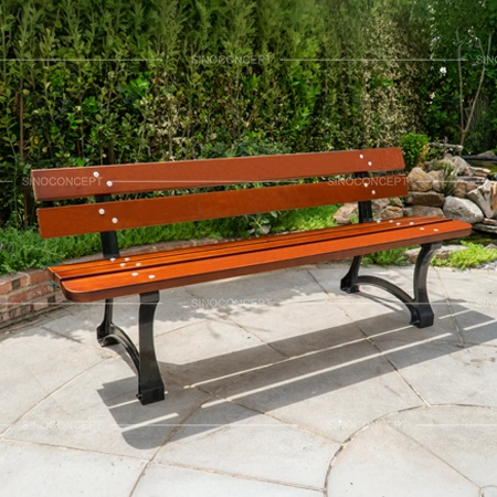 Outdoor benches and seating with wooden slats and cast iron legs installed in a landscaped public area