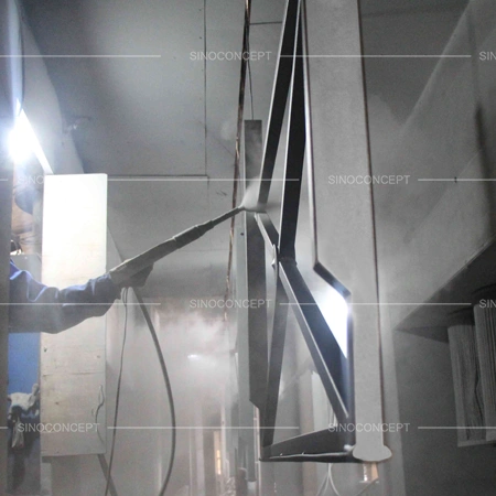 Worker spray coating pedestrian guardrails during surface treatment for outdoor corrosion protection
