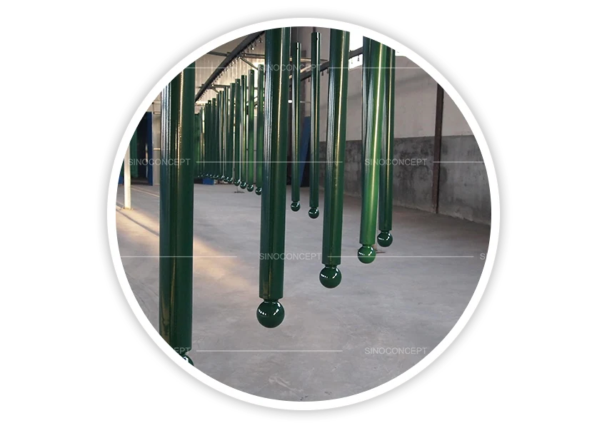 Street bollards hanging during UV-resistant powder coating process for durable outdoor finish