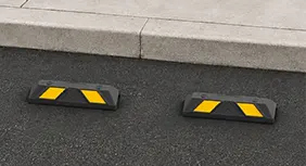 Wheel stop length comparison showing short paired wheel stops and a full-length parking wheel stop